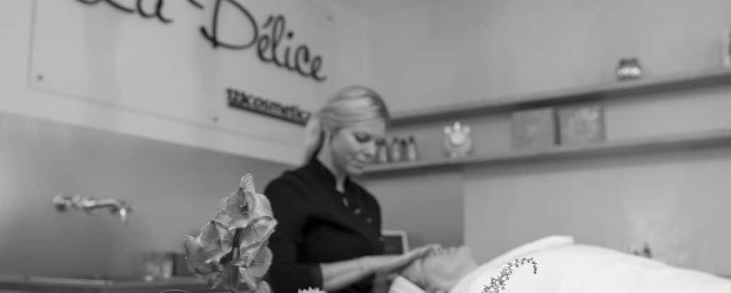 Jolanda tijdens een behandeling, met het La Délice-logo en 123cosmetica op de wand.